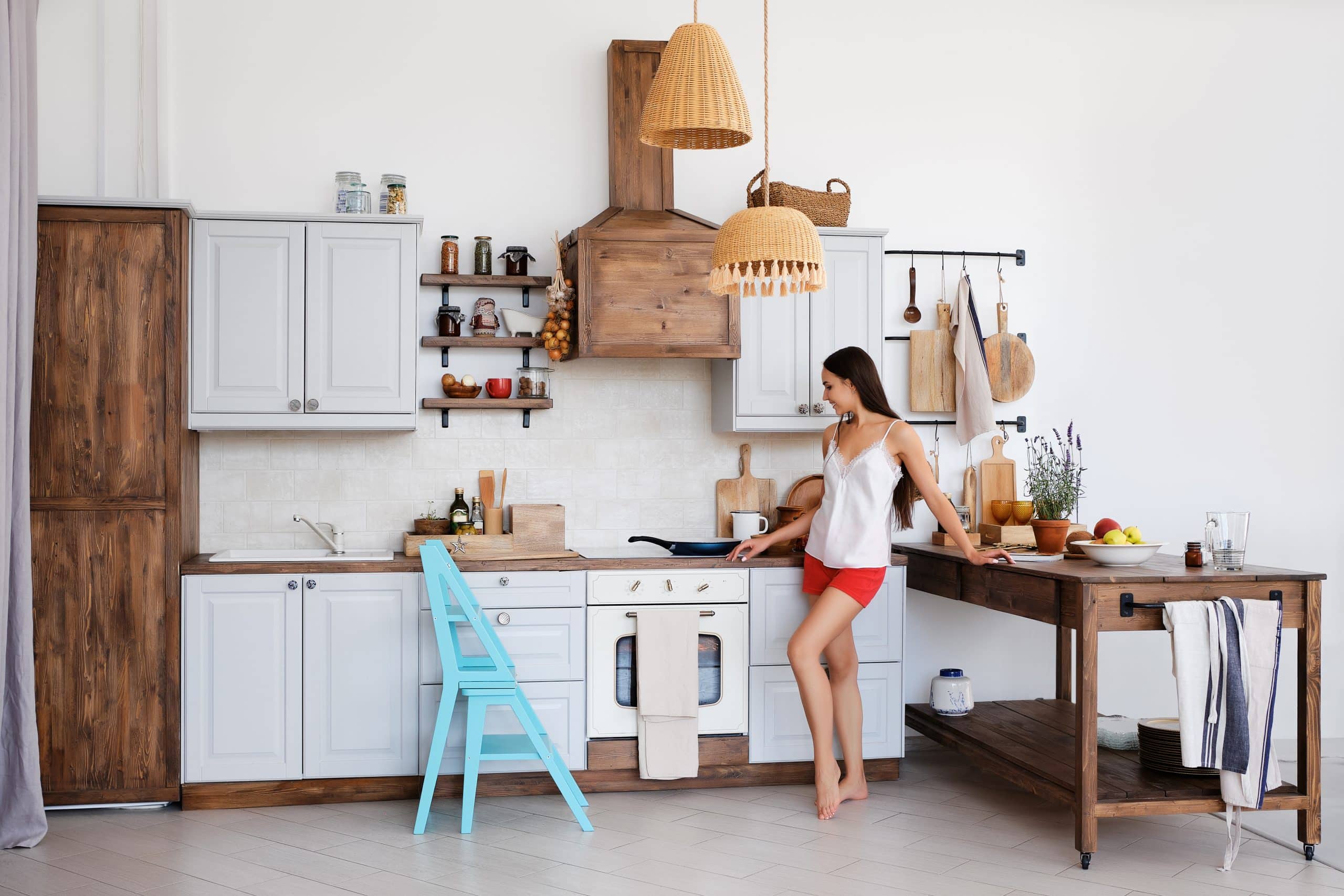 linda garota parada perto do fogão na cozinha